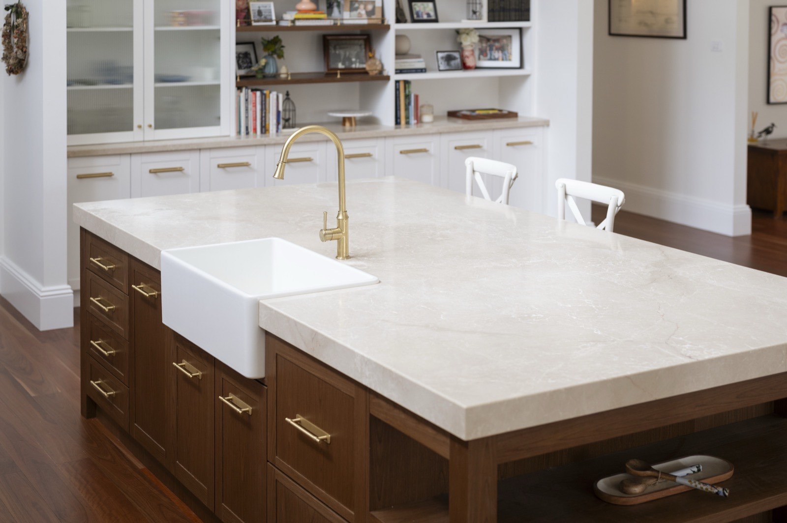 Farmhouse sink set into a stone island with brass tapware