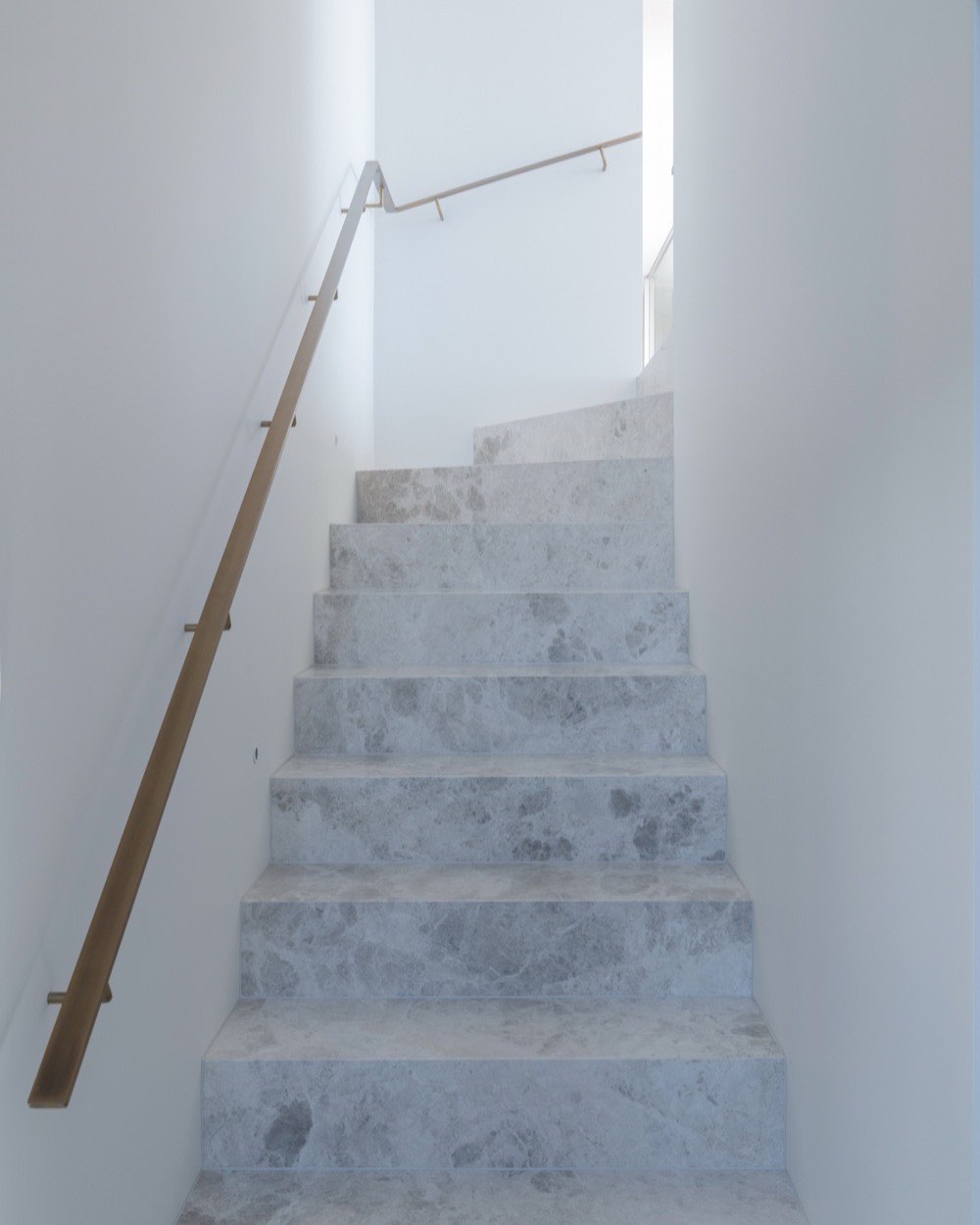 Marble stair treads with a brass handrail at Terrigal