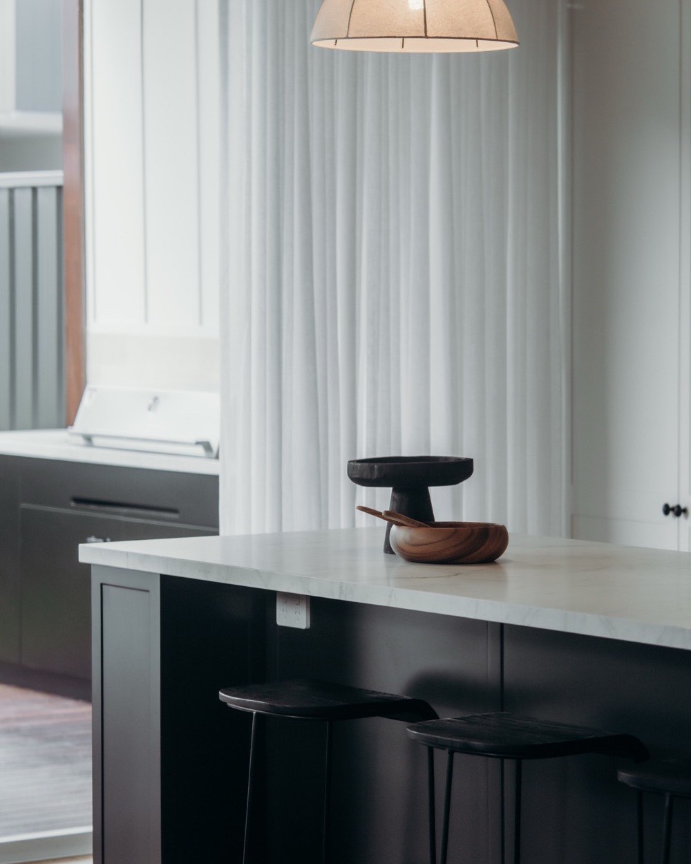 Black island with a light stone top and pendant light in Mayfield